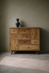 Wooden dresser with multiple drawers against a plain wall.
