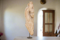 Wooden carvings on a stand against a neutral background
