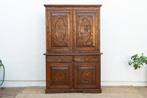 Wooden cabinet with decorative carvings on a white wall