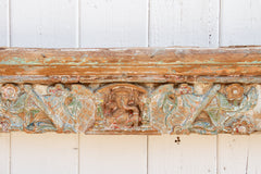 Decorative wooden panel with intricate carvings on a white wooden background