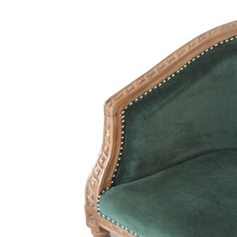 Green velvet armchair with wooden frame on a white background