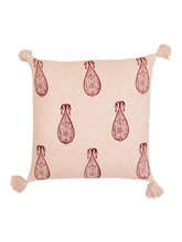Decorative pillow with red pattern and tassels on a pink background
