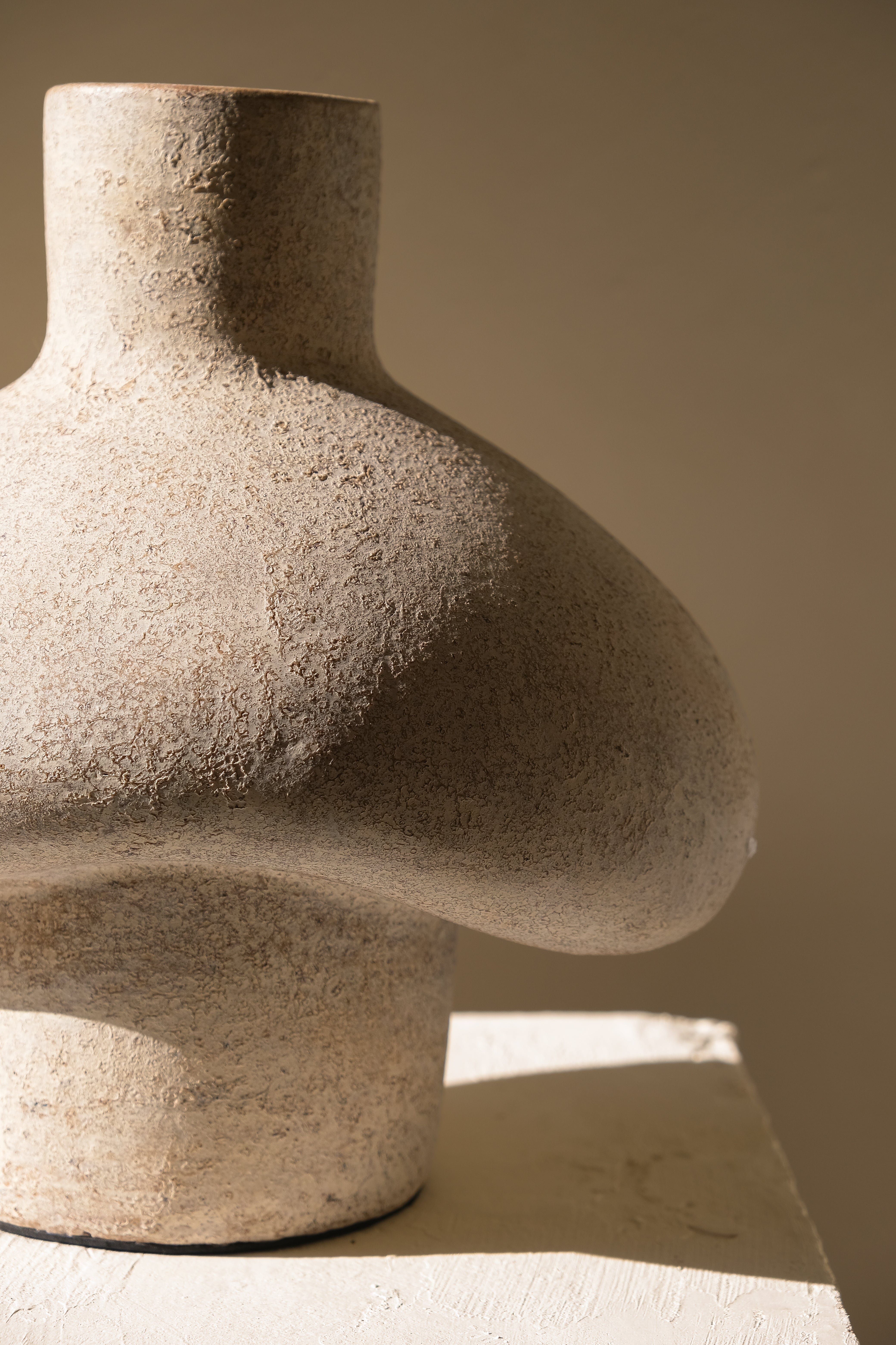 Stone sculpture resembling a human torso on a neutral background