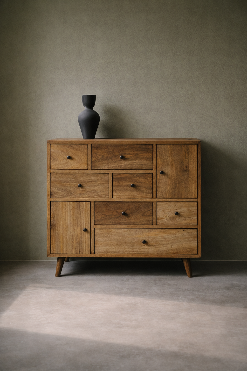 Wooden dresser with multiple drawers against a plain wall.