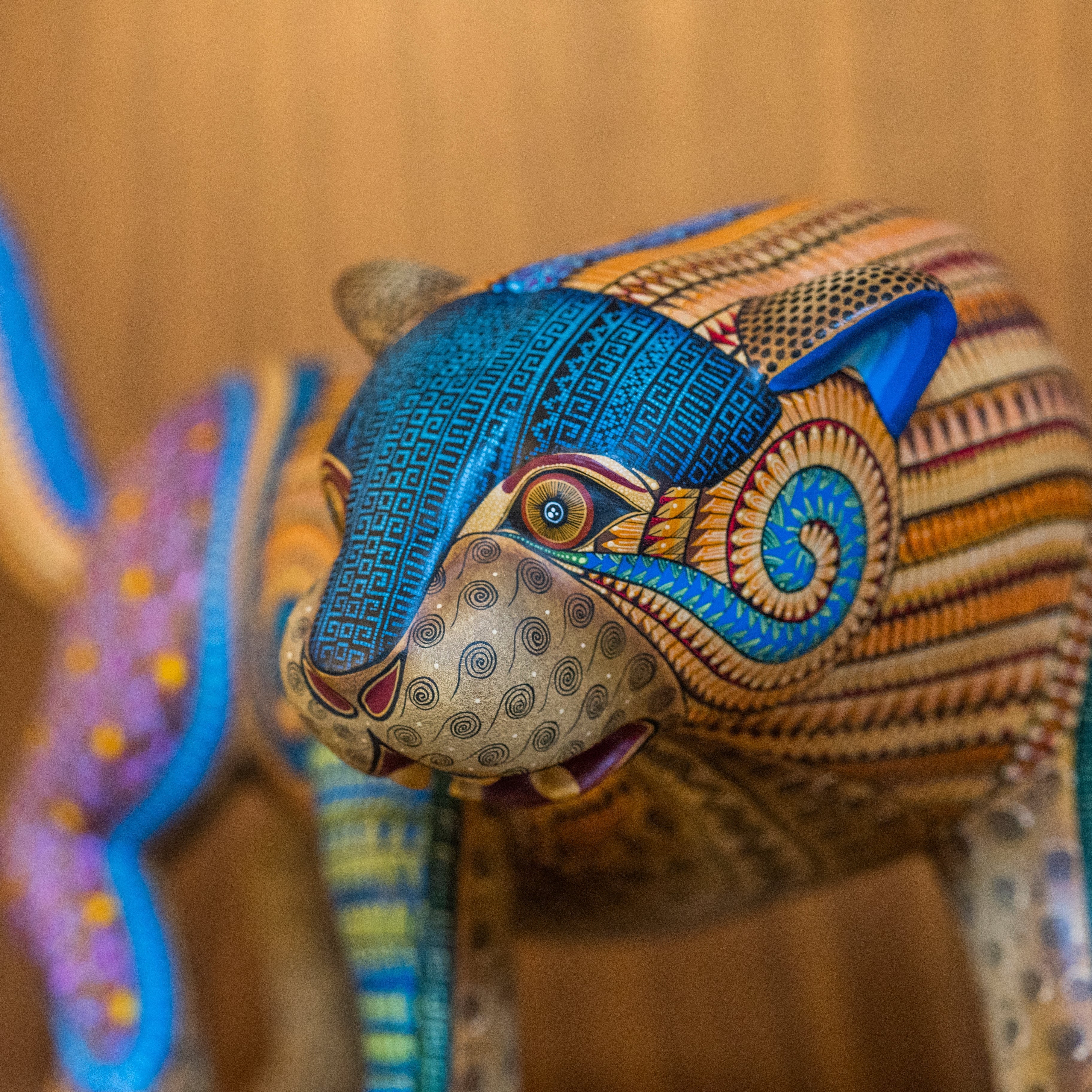 Colorful animal sculpture with intricate patterns on a wooden background