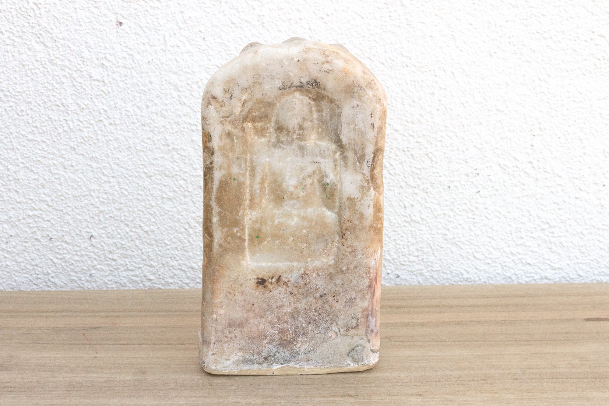 Block of soap with visible texture on a wooden surface and white background