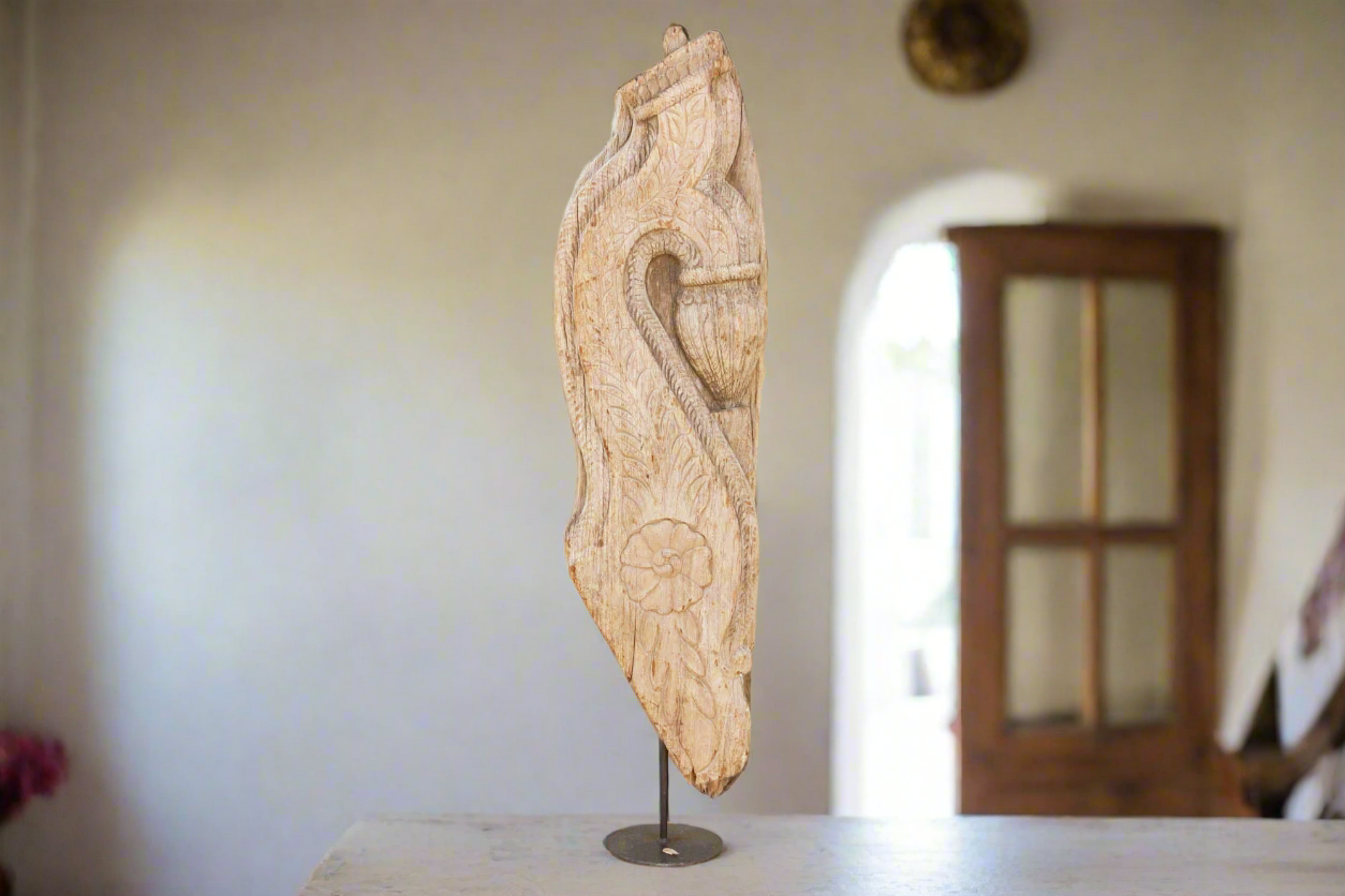 Wooden carvings on a stand against a neutral background
