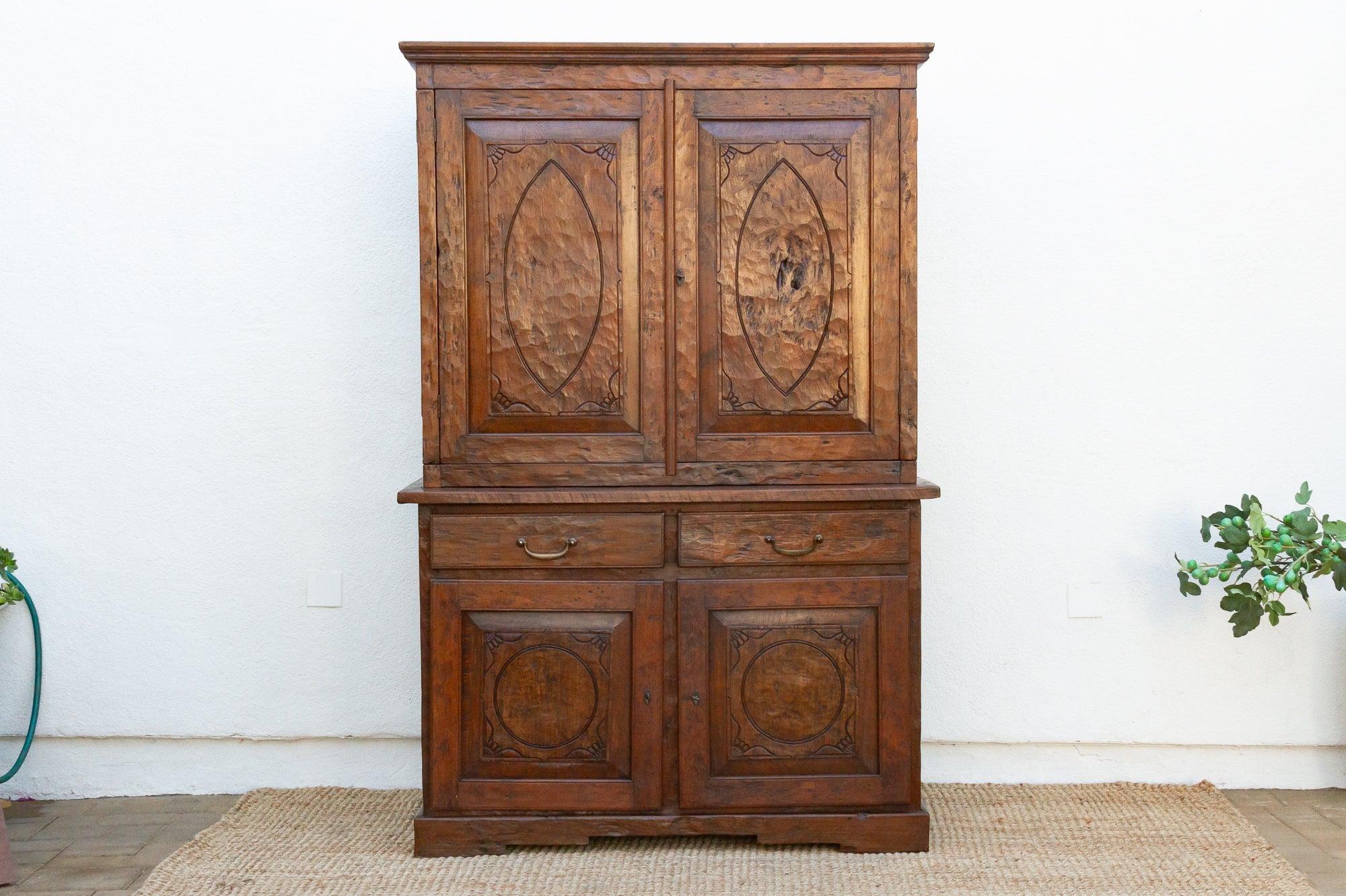 Wooden cabinet with decorative carvings on a white wall