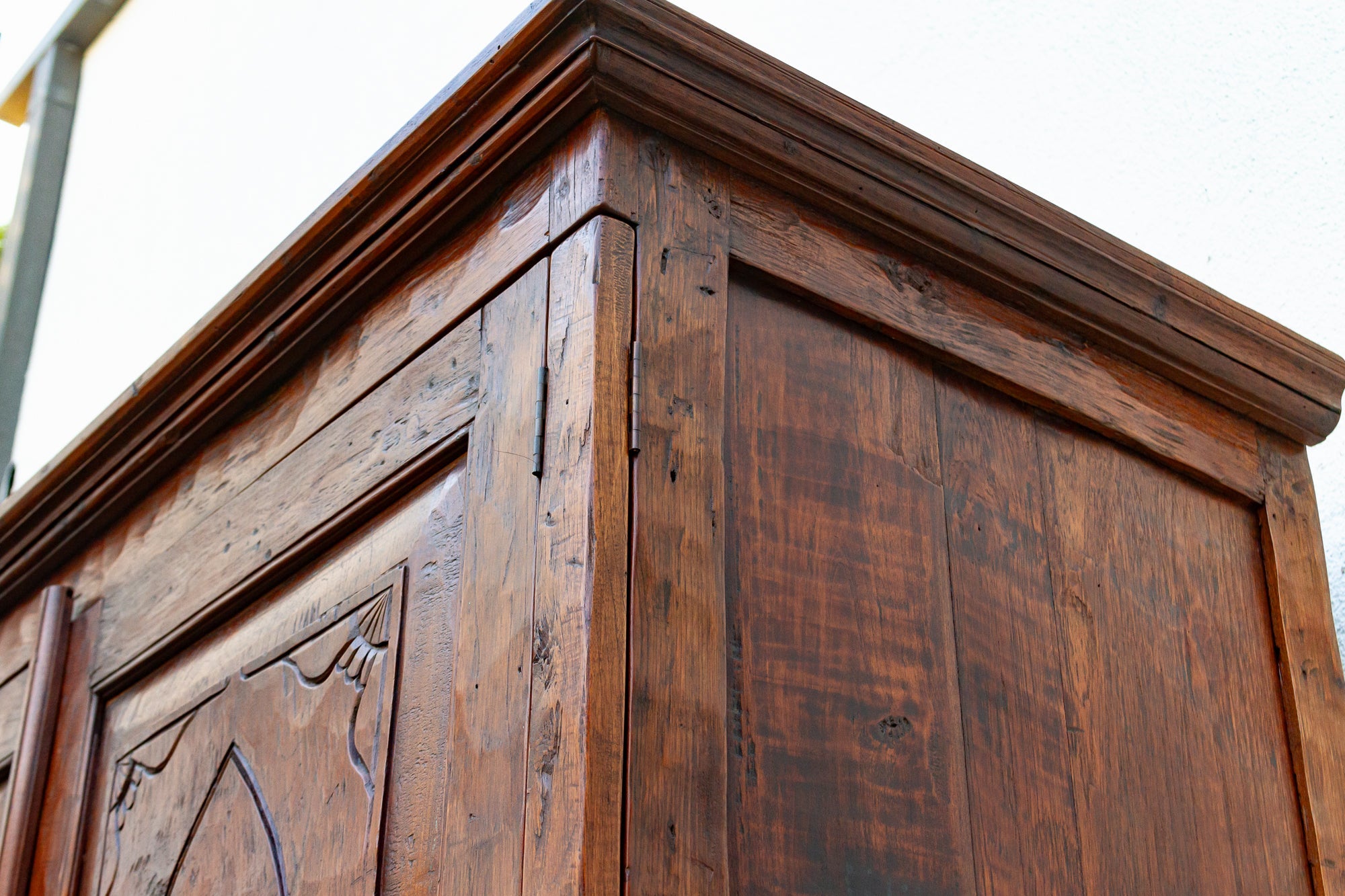 Close-up of a wooden wardrobe with intricate carvings on a white background