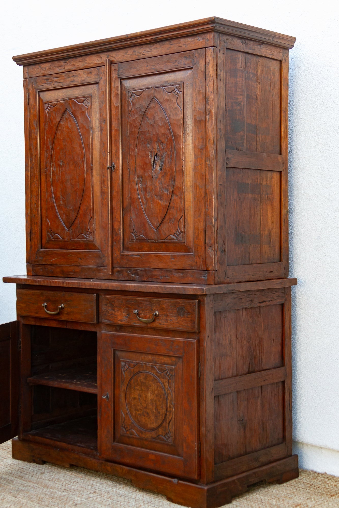 Wooden cabinet with intricate carvings on a white background