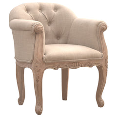 Beige armchair with tufted backrest and ornate wooden legs on a white background
