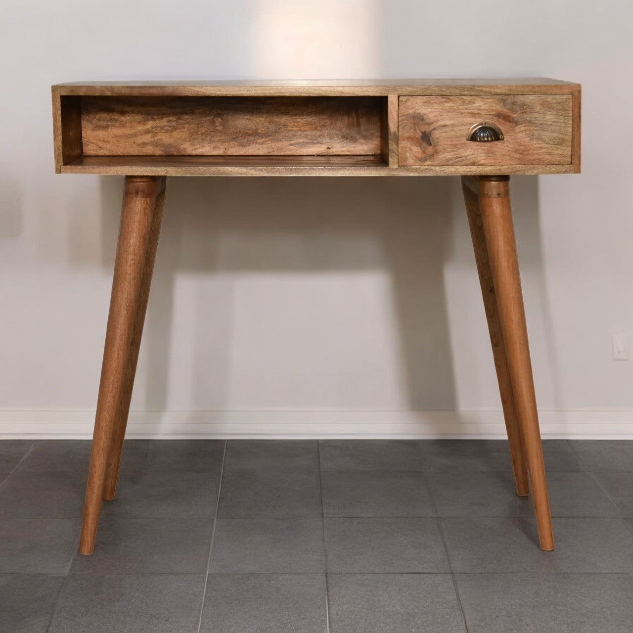 Wooden console table with two drawers on a gray tiled floor against a white wall.