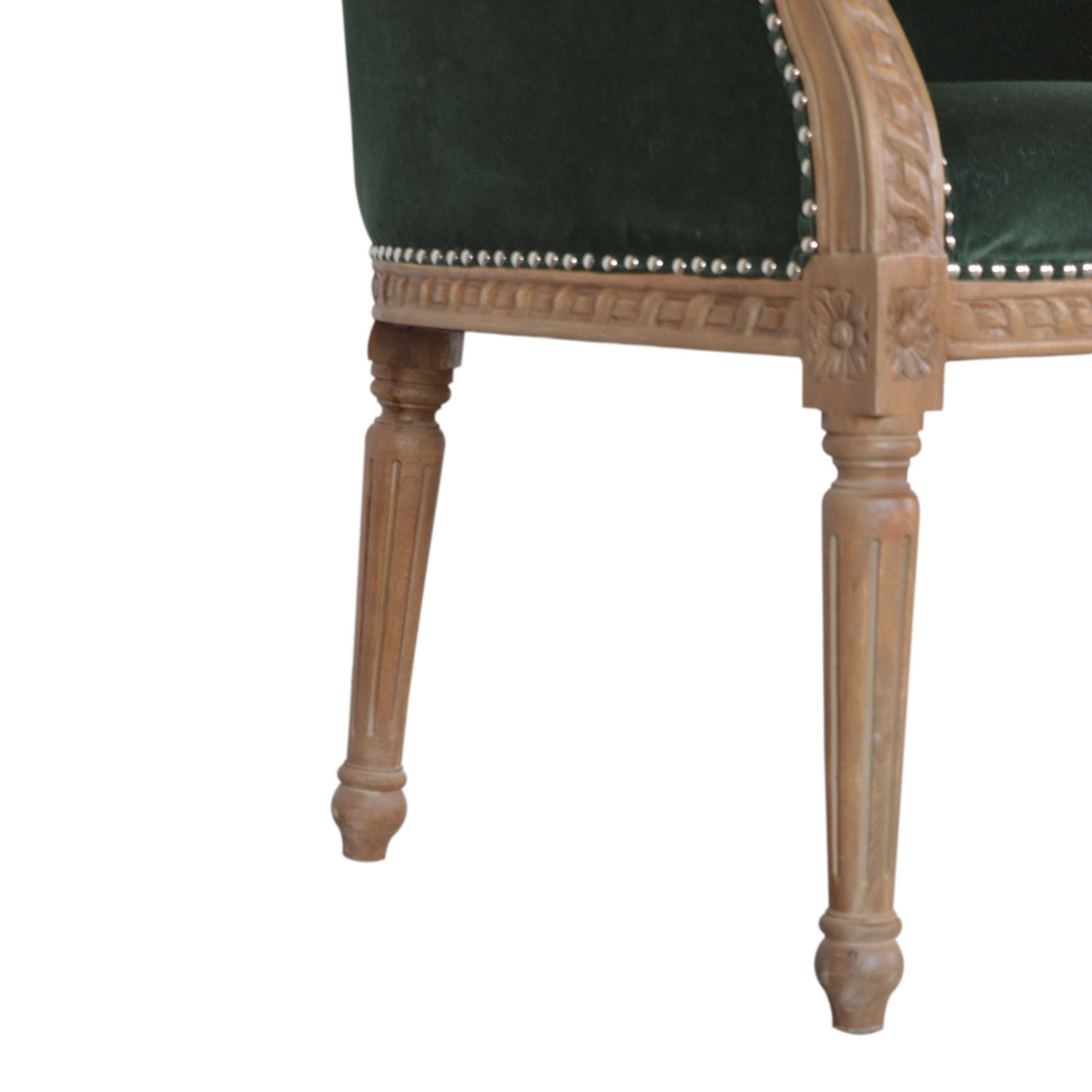 Close-up of a chair with green velvet upholstery and wooden legs on a white background