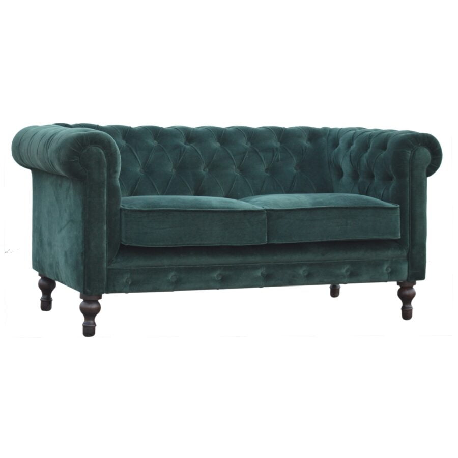 Green velvet sofa with tufted backrest on a white background