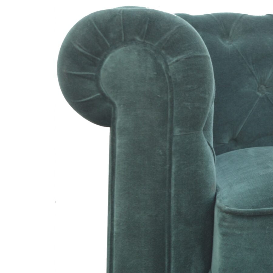 Close-up of a teal velvet armchair with tufted backrest on a white background