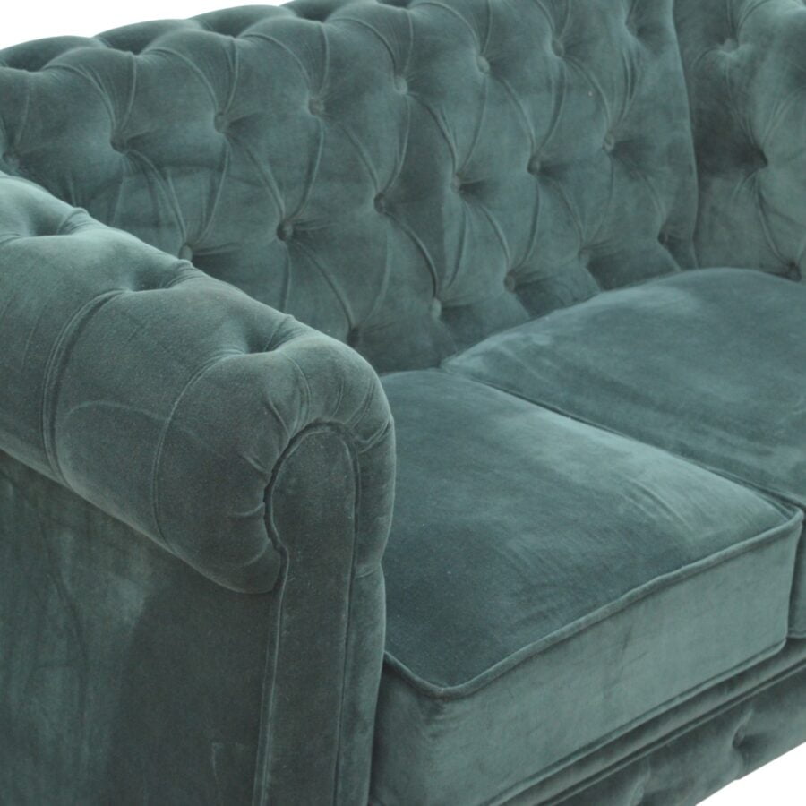 Teal velvet sofa with tufted backrest on a white background