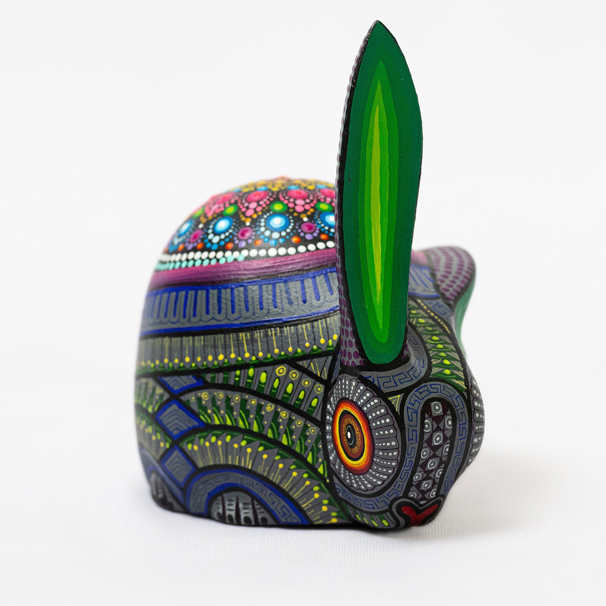 Colorful, intricately patterned rabbit sculpture on a white background