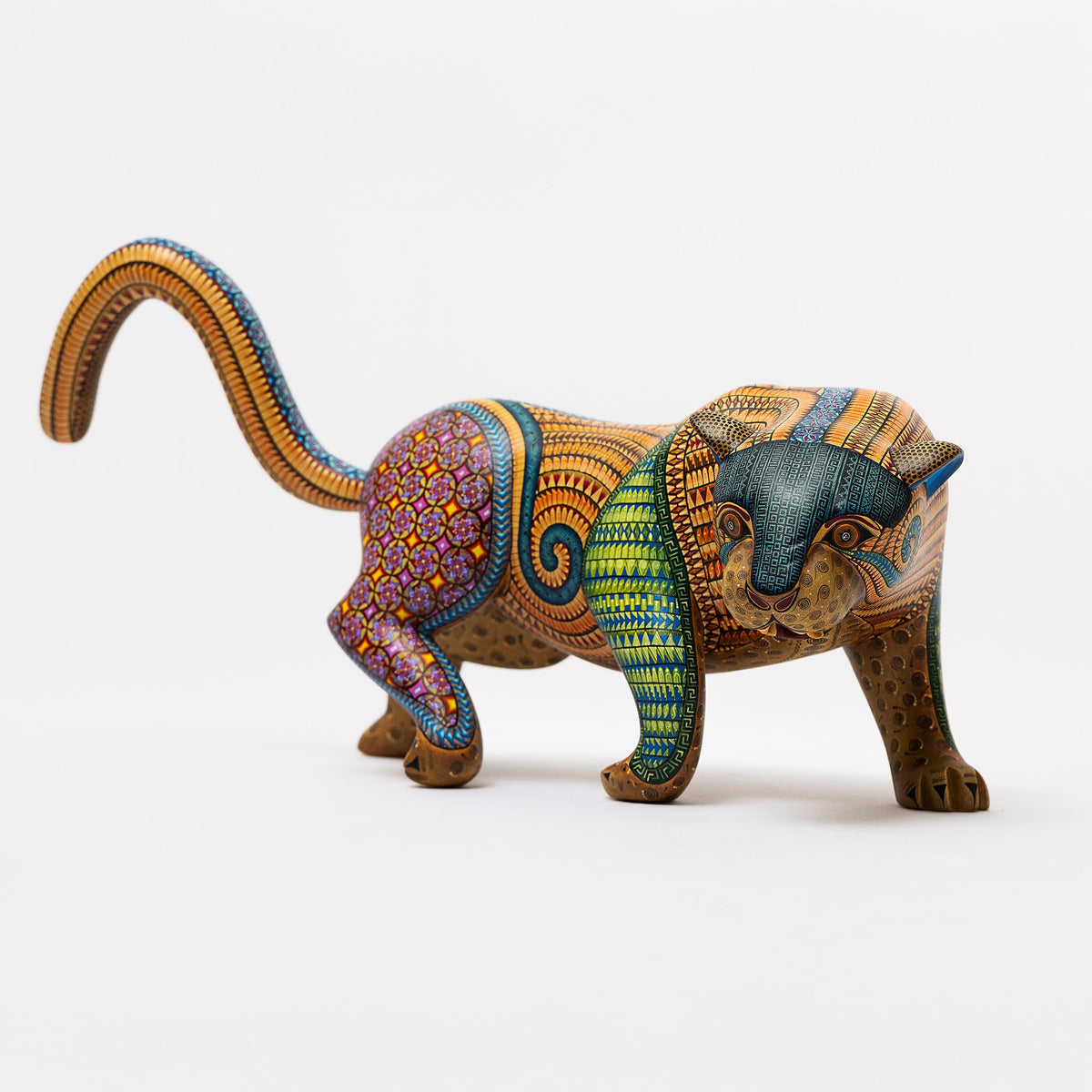 Colorful armadillo figurine with intricate patterns on a white background