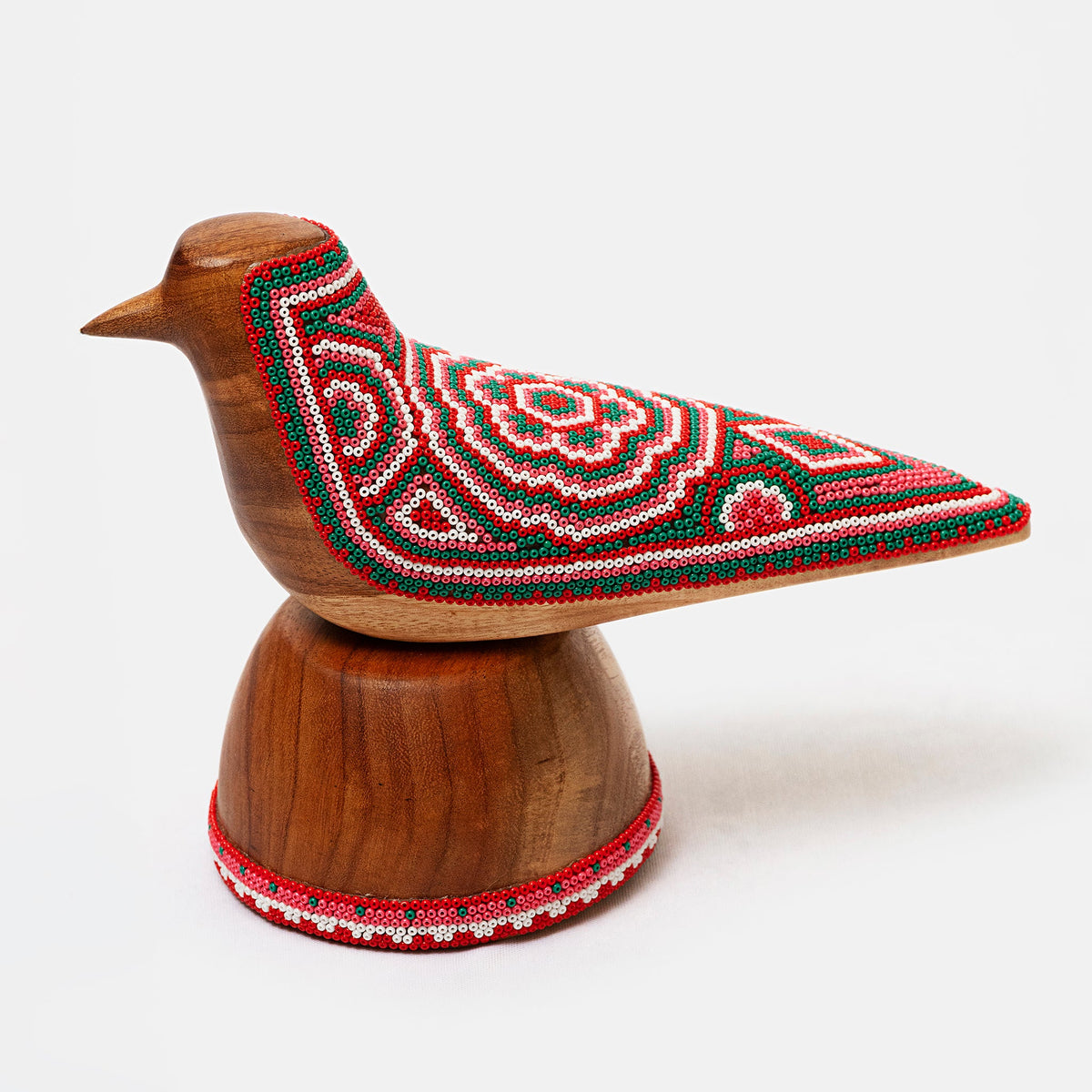 Wooden bird figurine with embroidered red and green pattern on a white background