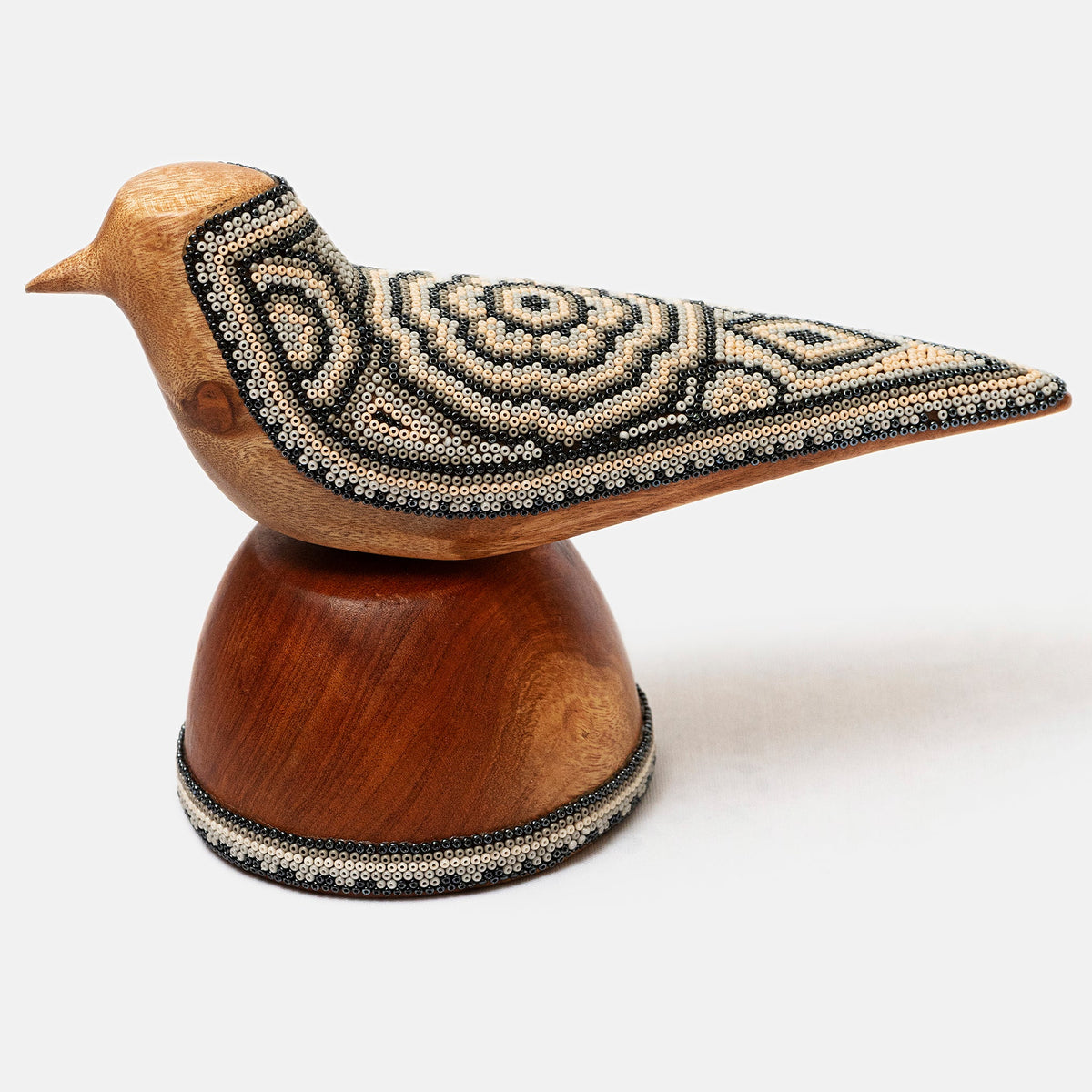 Wooden bird figurine with beaded details on a white background