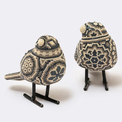 Two decorative birds made of beaded material on a white background