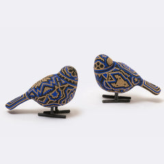 Two beaded bird figurines on stands against a white background