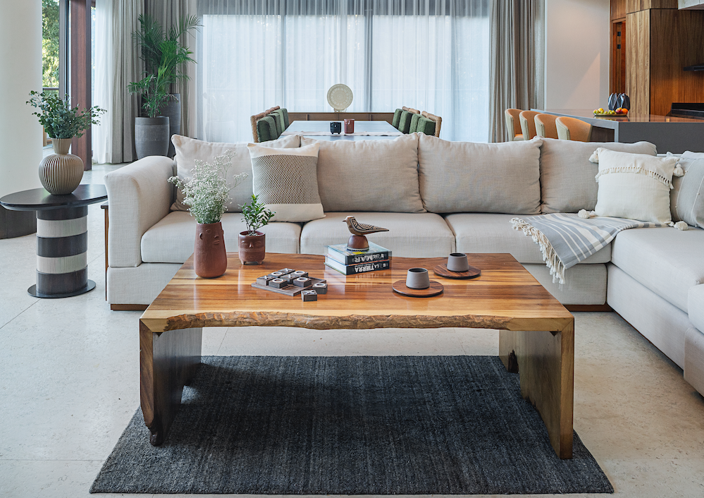 Modern living room with a sectional sofa, wooden coffee table, and decorative items.