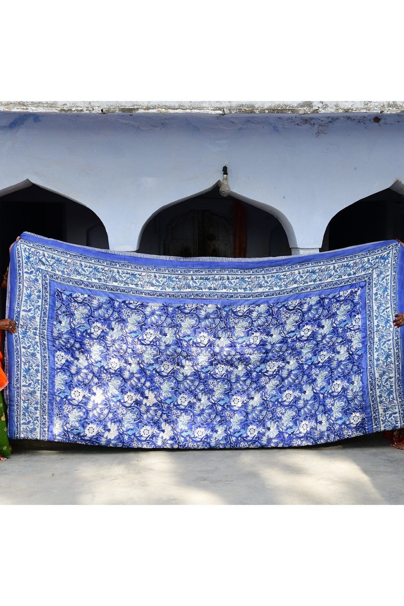 Blue floral-patterned fabric draped over a structure with arched windows.