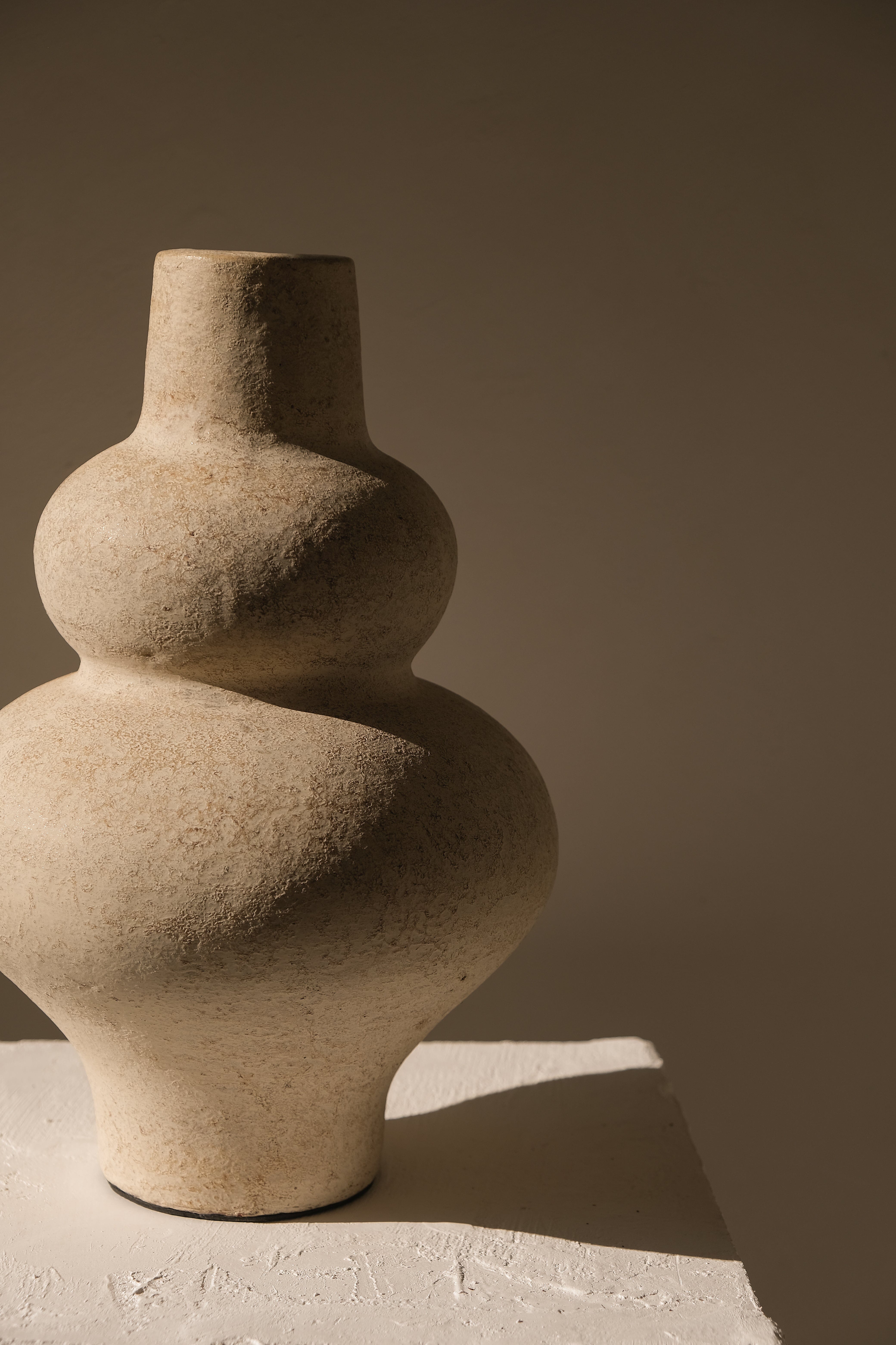 Stylized stone vase on a neutral background