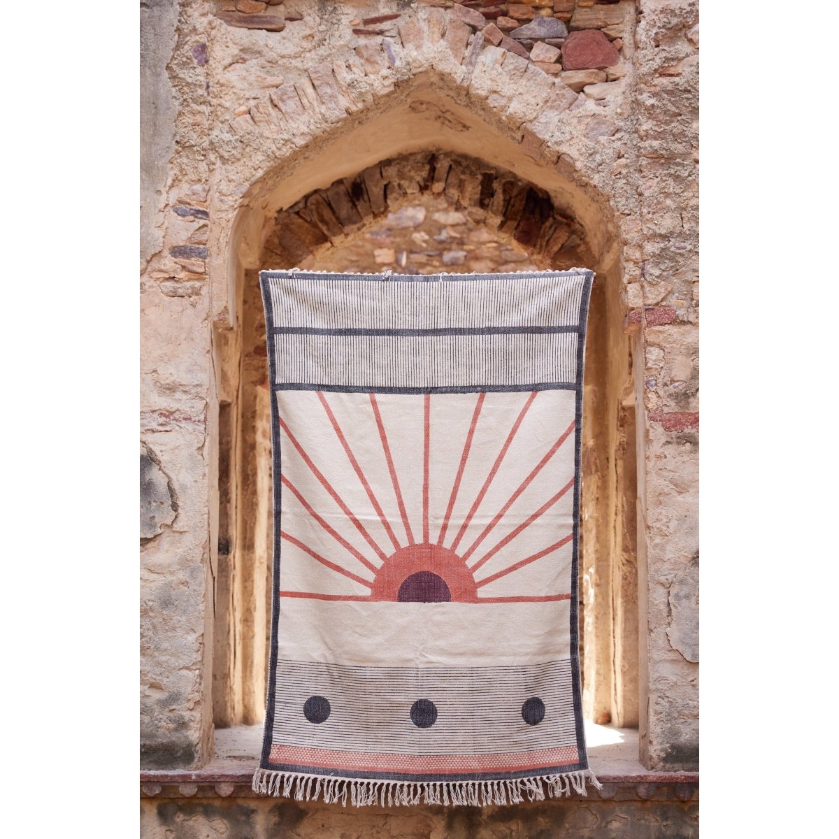 Textile with sun design hanging on a stone archway