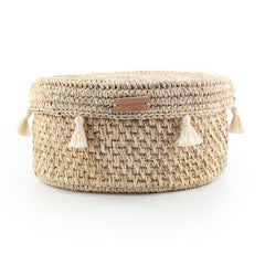 Woven basket with tassels and a visible brand label on a white background