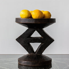 Decorative dark wood bowl with lemons on a light gray background