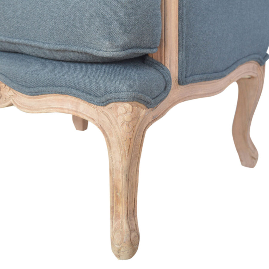 Close-up of a chair with blue cushioned backrest and wooden legs on a white background